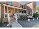Inviting front porch with white railing, a wooden door, and charming landscaping, creating a warm entrance at 5000 Bainbridge Sw Ct, Lilburn, GA 30047