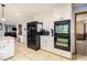 Open kitchen with stainless steel double ovens, black refrigerator, white cabinets, and tile flooring at 5000 Bainbridge Sw Ct, Lilburn, GA 30047
