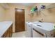 Functional laundry room featuring a modern washer and dryer with storage shelves and countertop at 5000 Bainbridge Sw Ct, Lilburn, GA 30047