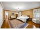 Large bedroom with hardwood floors, textured walls, elegant furnishings, and natural light at 705 W Ponce De Leon Ave, Decatur, GA 30030