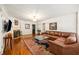 Spacious living room with hardwood floors, fireplace, large rug, and comfortable leather sectional sofa at 705 W Ponce De Leon Ave, Decatur, GA 30030