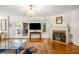 Cozy living room featuring hardwood floors, fireplace, large rug, and glass paneled doors to dining area at 705 W Ponce De Leon Ave, Decatur, GA 30030