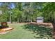 Well-maintained backyard with a sandbox and shed surrounded by lush trees and greenery at 1079 Pinedale Se Dr, Smyrna, GA 30080