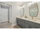 Bathroom featuring double vanity with modern faucets, white walls, and views of the glass enclosed tiled shower at 1079 Pinedale Se Dr, Smyrna, GA 30080