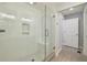 Bathroom featuring white subway tile shower, glass door, built-in bench, and a door leading to the hallway at 1079 Pinedale Se Dr, Smyrna, GA 30080