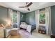 Bedroom with a cozy atmosphere featuring green walls, a black bed, two windows, and a decorative ceiling fan at 1079 Pinedale Se Dr, Smyrna, GA 30080
