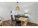Light and airy dining area featuring hardwood floors, a wooden table with black chairs, and decorative lighting fixture at 1079 Pinedale Se Dr, Smyrna, GA 30080