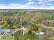 Overhead view of a modern home surrounded by mature trees, a manicured lawn, and a long, paved driveway at 1540 Brooks S Rd, Lawrenceville, GA 30045