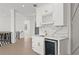 Stylish bar area with white cabinetry, a beverage fridge, marble backsplash, and gold hardware accents at 1540 Brooks S Rd, Lawrenceville, GA 30045