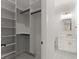 Bright walk-in closet and bathroom featuring a white vanity with stone countertops and a frameless mirror at 1540 Brooks S Rd, Lawrenceville, GA 30045