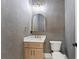Modern powder room boasts stylish vanity, elegant gold fixtures, and unique textured gray walls at 1540 Brooks S Rd, Lawrenceville, GA 30045