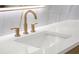 Close-up of a stylish bathroom sink with modern gold fixtures and a sleek white countertop at 1540 Brooks S Rd, Lawrenceville, GA 30045