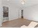 Bright bedroom with light hardwood flooring, white trim, and an ensuite bathroom with tiled shower and tub at 1540 Brooks S Rd, Lawrenceville, GA 30045