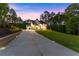 Extra long driveway leading up to the home, showcasing the home's exterior lighting at dusk at 1540 Brooks S Rd, Lawrenceville, GA 30045