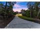 Long driveway leads to modern two-story home, landscaped with trees and manicured lawn at dusk at 1540 Brooks S Rd, Lawrenceville, GA 30045