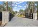 Long driveway leading to a modern two-story brick and stone home with black trim and gated entrance at 1540 Brooks S Rd, Lawrenceville, GA 30045