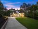 Custom home featuring modern design elements, a sweeping driveway, and lush greenery, creating a luxurious and inviting ambiance at 1540 Brooks S Rd, Lawrenceville, GA 30045