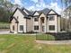 Two-story brick and stone home featuring black-framed windows and a landscaped yard with black metal fence at 1540 Brooks S Rd, Lawrenceville, GA 30045
