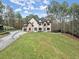 View of the two-story home from the yard with a long driveway leading to the black trimmed house at 1540 Brooks S Rd, Lawrenceville, GA 30045