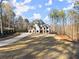 Beautiful modern home featuring a manicured lawn, long driveway, and lush surrounding trees at 1540 Brooks S Rd, Lawrenceville, GA 30045