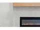 Modern fireplace with a sleek black frame and a light wood mantle complementing the textured gray wall at 1540 Brooks S Rd, Lawrenceville, GA 30045
