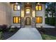 Home's front entrance featuring stone pillars, modern door, and manicured landscaping at 1540 Brooks S Rd, Lawrenceville, GA 30045