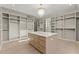 Spacious walk-in closet with custom shelving, center island, and elegant chandelier at 1540 Brooks S Rd, Lawrenceville, GA 30045