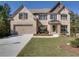 Beautiful two-story home with brick and siding, featuring a well-kept lawn, attached garage, and mature trees at 1993 Side Branch Way, Lawrenceville, GA 30045