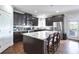 Modern kitchen featuring dark wood cabinets, stainless steel appliances, a large island, and hardwood floors at 1993 Side Branch Way, Lawrenceville, GA 30045