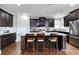 Well-equipped kitchen featuring dark wood cabinets, granite countertops, and a central island with seating at 1993 Side Branch Way, Lawrenceville, GA 30045