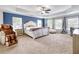 Spacious main bedroom with tray ceilings, plush carpet, natural light and a massage chair at 1993 Side Branch Way, Lawrenceville, GA 30045