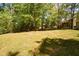 Large grassy backyard with mature trees and sunlight at 605 Sutton Sw Way, Marietta, GA 30064