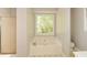 Bathroom featuring a soaking tub with a large window offering a backyard view at 605 Sutton Sw Way, Marietta, GA 30064