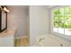 Bathroom with a bathtub, shower, and a window providing natural light at 605 Sutton Sw Way, Marietta, GA 30064