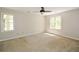 Bright bedroom with neutral carpet, ceiling fan, and natural light from two windows at 605 Sutton Sw Way, Marietta, GA 30064