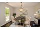 Dining room featuring a black marble table, light-colored chairs, stylish light fixture, and natural lighting at 605 Sutton Sw Way, Marietta, GA 30064