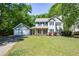 Charming two-story home with a lush green lawn and a detached two-car garage, surrounded by mature trees at 605 Sutton Sw Way, Marietta, GA 30064