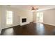 Spacious living room featuring dark wood flooring, a white fireplace, and ample natural light at 605 Sutton Sw Way, Marietta, GA 30064