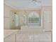 Bright bathroom showcasing a glass shower, separate tub, tile floors, and an arched window at 3105 Birchton St, Johns Creek, GA 30022