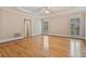 Spacious bedroom with tray ceilings, hardwood floors, ceiling fan, and natural light from shuttered windows at 3105 Birchton St, Johns Creek, GA 30022