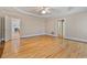 Large bedroom featuring hardwood floors, tray ceiling, ceiling fan, and an open doorway to another room at 3105 Birchton St, Johns Creek, GA 30022