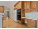 Well-equipped kitchen with wood cabinets, modern appliances, and a bright adjacent hallway at 3105 Birchton St, Johns Creek, GA 30022