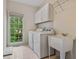 Bright laundry room features a washing machine, dryer, sink, and storage cabinets at 3105 Birchton St, Johns Creek, GA 30022