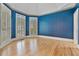 Bright living room featuring hardwood floors, blue wallpaper, and shuttered windows at 3105 Birchton St, Johns Creek, GA 30022