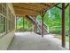 Covered patio with an outdoor staircase leading to the backyard and green surroundings at 3105 Birchton St, Johns Creek, GA 30022