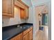 Wet bar featuring wood cabinets, black countertop, gold faucet and doorway leading to another room at 3105 Birchton St, Johns Creek, GA 30022