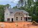 Two-story brick home with gray siding, an attached garage, and a covered front porch at 3294 Mill Forest Dr, Conyers, GA 30094