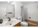 Bright bathroom with vanity, sink, toilet, and shower-tub combo with tiled walls and a neutral curtain at 3400 Bonds Lake Nw Rd, Conyers, GA 30012