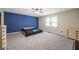 Spacious bedroom featuring neutral carpet, a blue accent wall, and lots of natural light from the window at 3400 Bonds Lake Nw Rd, Conyers, GA 30012