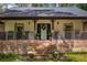 Close up of a cozy porch with brick steps, rocking chairs, and decorative plants creating a welcoming entrance at 3400 Bonds Lake Nw Rd, Conyers, GA 30012